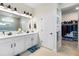 Stylish bathroom featuring a double vanity, white cabinets, and walk-in shower with tile surround at 8916 Windlass Cv, Parrish, FL 34219