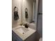 Well-lit bathroom features a square sink with black hardware, quartz countertops, and a decorative towel ring at 8916 Windlass Cv, Parrish, FL 34219