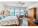 Bright bedroom with wood furniture, bed with floral pattern, and a view of the outdoors at 8916 Windlass Cv, Parrish, FL 34219