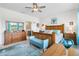 Well-lit bedroom featuring a wood bed frame, blue accents, and a large dresser at 8916 Windlass Cv, Parrish, FL 34219