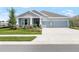 Charming single-story home with a three-car garage, inviting front porch, and well-manicured lawn at 8916 Windlass Cv, Parrish, FL 34219
