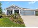 Charming single-story home with a three-car garage, inviting front porch, and beautifully landscaped yard at 8916 Windlass Cv, Parrish, FL 34219