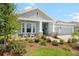 Landscaped front yard featuring a charming single-story home with a three-car garage and inviting front porch at 8916 Windlass Cv, Parrish, FL 34219