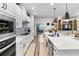 This modern kitchen features stainless steel appliances, white cabinets, quartz countertops, and pendant lights at 8916 Windlass Cv, Parrish, FL 34219
