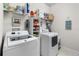 Bright laundry room equipped with a washer, dryer, and ample shelving for storage and organization at 8916 Windlass Cv, Parrish, FL 34219