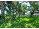 Lush backyard showcasing vibrant greenery, mature trees, and a glimpse of the serene waterfront at 8927 Key West Island Way, Riverview, FL 33578