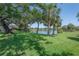 Lush green lawn with mature trees and a tranquil lake, creating a serene and picturesque backyard setting at 8927 Key West Island Way, Riverview, FL 33578