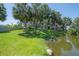 Well-maintained backyard with palm trees and water view, creating a beautiful and relaxing outdoor environment at 8927 Key West Island Way, Riverview, FL 33578