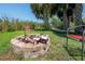 Cozy fire pit area with chairs, marshmallows, and a hammock, surrounded by palm trees, ideal for gatherings at 8927 Key West Island Way, Riverview, FL 33578