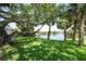 Expansive backyard features lush green grass and mature trees overlooking a serene lake, offering a private oasis at 8927 Key West Island Way, Riverview, FL 33578