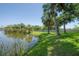 Backyard with lush landscaping and a view of the serene lake, offering a tranquil retreat at 8927 Key West Island Way, Riverview, FL 33578