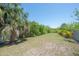 Spacious backyard with mature trees and a wall offering privacy and a touch of nature, perfect for outdoor enjoyment at 8927 Key West Island Way, Riverview, FL 33578