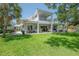 Expansive backyard features covered patio, lush green lawn, and mature shade trees at 8927 Key West Island Way, Riverview, FL 33578