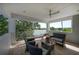This neutral covered balcony features a table, chairs, ceiling fan, views of a lake, and natural lighting at 8927 Key West Island Way, Riverview, FL 33578