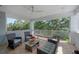 Covered balcony featuring neutral furniture, ceiling fan, tile floor, and views of surrounding foliage at 8927 Key West Island Way, Riverview, FL 33578