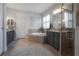 This bathroom features a soaking tub, gray vanity, and a large format tile floor at 8927 Key West Island Way, Riverview, FL 33578
