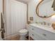Bright bathroom featuring a white vanity with a round mirror and a shower with a white curtain at 8927 Key West Island Way, Riverview, FL 33578