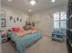 Comfortable bedroom featuring unique wall decor, a playful theme, and a bright window with shutters at 8927 Key West Island Way, Riverview, FL 33578