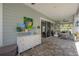 Stylish covered patio with a console, seating area, and views of the backyard and play structure at 8927 Key West Island Way, Riverview, FL 33578