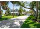 Stunning two-story home with a lush green lawn, palm trees, and a long driveway at 8927 Key West Island Way, Riverview, FL 33578