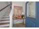 Inviting foyer with hardwood stairs, console table, and a blue front door with glass at 8927 Key West Island Way, Riverview, FL 33578