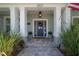 Close-up of the front porch and doorway with beautiful potted plants and a wreath on the door at 8927 Key West Island Way, Riverview, FL 33578