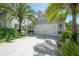 Well-maintained garage and driveway framed by mature palm trees and landscaping at 8927 Key West Island Way, Riverview, FL 33578