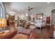 Open-concept living room with stylish seating, hardwood floors, and a view into the kitchen area at 8927 Key West Island Way, Riverview, FL 33578
