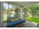 Relaxing covered porch with a comfortable swing overlooking a lush backyard and lake at 8927 Key West Island Way, Riverview, FL 33578