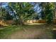 Large backyard featuring a wooden fence and mature trees, providing privacy and shade at 9025 1St Ne Ave, St Petersburg, FL 33702