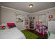 Bedroom features a large window with blind, a full bed, white dresser and colorful decor at 9025 1St Ne St, St Petersburg, FL 33702