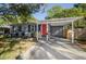 Charming single-story home featuring a bright red front door and covered carport at 9025 1St Ne Ave, St Petersburg, FL 33702