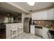 Open kitchen features stainless steel appliances, white cabinets, and adjacent living room at 9025 1St Ne St, St Petersburg, FL 33702