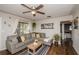 Cozy living room features a sectional sofa, ceiling fan, and a large window for natural light at 9025 1St Ne St, St Petersburg, FL 33702