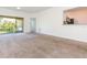 Open living room with carpet flooring and a passthrough to the kitchen at 9524 Newdale Way # 101, Riverview, FL 33578
