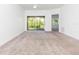 Bright living room with neutral carpet, ceiling fan, and sliding glass doors at 9524 Newdale Way # 101, Riverview, FL 33578