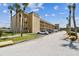 Condominium complex with neutral stucco, balconies, well-maintained landscaping, parking and palm trees at 1 Boca Ciega Point Blvd # 310, St Petersburg, FL 33708