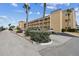 Condominium community exterior featuring palm trees, ample parking, and a well-maintained landscape at 1 Boca Ciega Point Blvd # 310, St Petersburg, FL 33708
