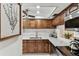 Kitchen featuring stainless steel appliances, wood cabinetry, neutral backsplash, and a granite countertop at 1 Boca Ciega Point Blvd # 310, St Petersburg, FL 33708