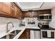 Kitchen featuring stainless steel appliances, wood cabinetry, granite counters, and neutral backsplash at 1 Boca Ciega Point Blvd # 310, St Petersburg, FL 33708