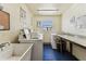 Bright laundry room featuring multiple washing machines, a utility sink, and a folding table at 1 Boca Ciega Point Blvd # 310, St Petersburg, FL 33708