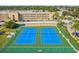 Aerial view of community tennis courts in meticulously kept landscaping near condos at 1 Boca Ciega Point Blvd # 310, St Petersburg, FL 33708