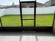 An open view from the screened in patio out to the lush green backyard at 10766 Standing Stone Dr, Wimauma, FL 33598