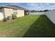 A view of the huge backyard with new white fence at 10766 Standing Stone Dr, Wimauma, FL 33598