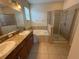 Bathroom with double sinks, large mirror, soaking tub and glass shower at 10766 Standing Stone Dr, Wimauma, FL 33598