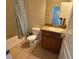 A cozy bathroom features a toilet, vanity with a sink, and a bathtub with a patterned curtain at 10766 Standing Stone Dr, Wimauma, FL 33598