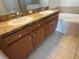 Bathroom vanity with double sinks, storage, and tile flooring at 10766 Standing Stone Dr, Wimauma, FL 33598