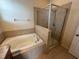 Bright bathroom featuring a soaking tub and glass-enclosed shower with tiled surround at 10766 Standing Stone Dr, Wimauma, FL 33598