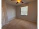 A carpeted bedroom featuring a ceiling fan and a window with blinds at 10766 Standing Stone Dr, Wimauma, FL 33598