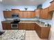 Stylish kitchen showcasing granite countertops, wood cabinets, and stainless steel appliances at 10766 Standing Stone Dr, Wimauma, FL 33598